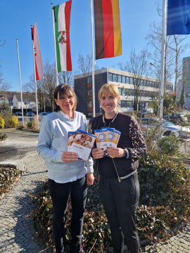 Kerstin Rohdenburg und Lena Schäfers, Kita-Fachberaterinnen beim Kreisjugendamt Paderborn, mit Infomaterial zu den Angeboten in den Familienzentren im Kreis (v.l.).
